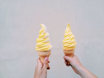 Woman holding ice cream cone against white background