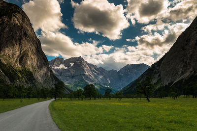 Country road against cloudy sky