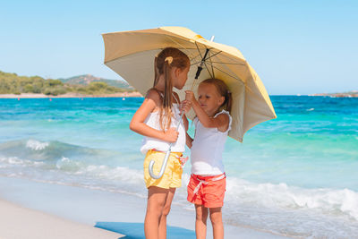 Side view of woman with umbrella at beach