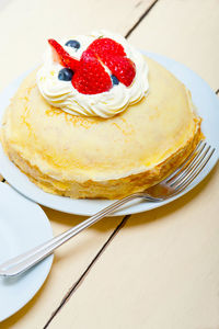 Crepe pancake cake with whipped cream and strawberry on top