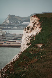 Scenic view of sea by city against sky