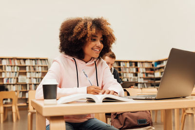 Young woman using laptop at table