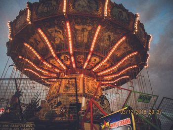 Low angle view of illuminated ferris wheel against sky at night