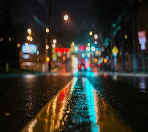 Illuminated city street during rainy season at night