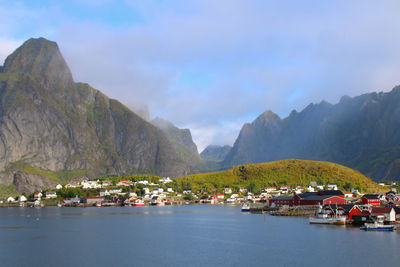 Boats in sea with mountain range in background