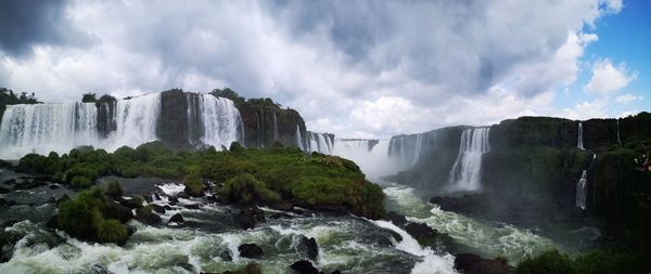 Panoramic view of iguazu waterfalls against cloudy sky