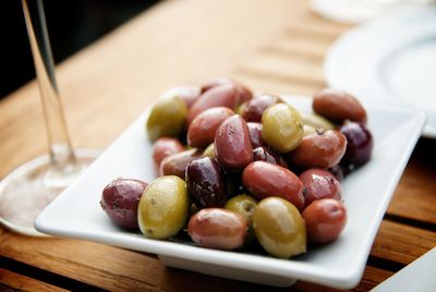 Close-up of pickled olives in tray on table