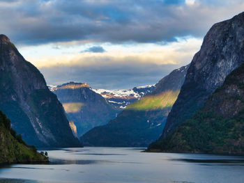 Scenic view of mountains and lake against cloudy sky