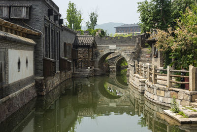 Arch bridge over canal amidst buildings