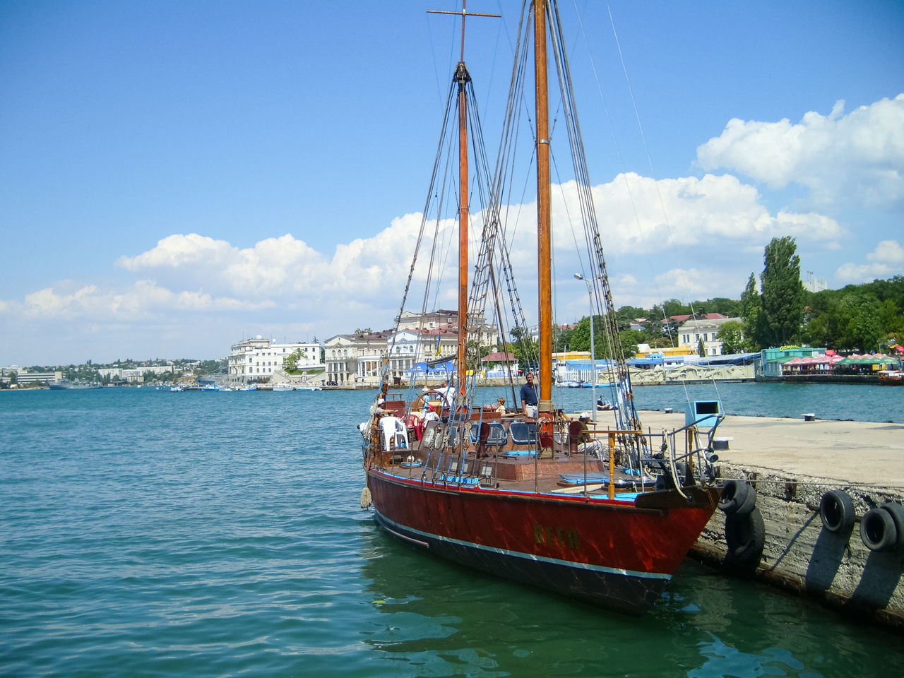 SAILBOATS MOORED IN SEA AGAINST SKY