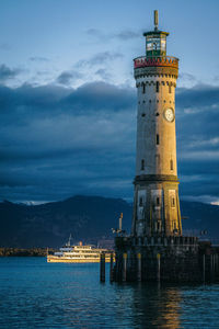 View of lighthouse by sea against sky