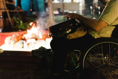 Man sitting on fire at night