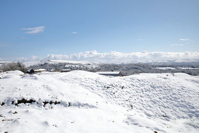 Snow covered land against sky