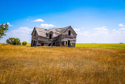 Old house on field against sky