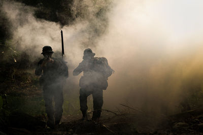 Army soldiers walking on smoky filed