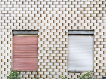 Closed window shutters on patterned wall