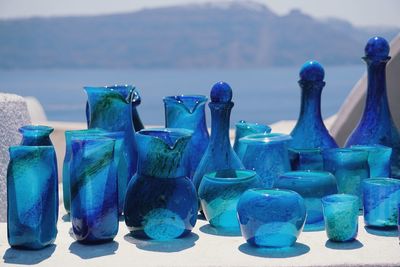 Close-up of glasses on table against sea