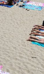 Low section of women relaxing on beach