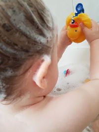 Baby boy playing with toy in bathtub