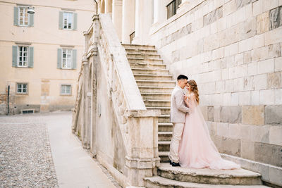 Couple holding umbrella in front of building