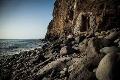 Rocks on beach against clear sky