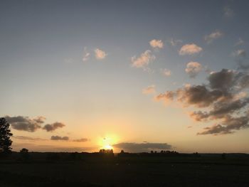 Scenic view of silhouette field against sky during sunset
