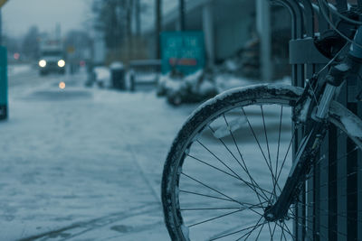 Close-up of bicycle wheel on sidewalk during winter