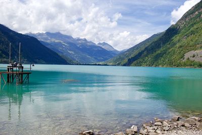 Scenic view of lake by mountains against sky