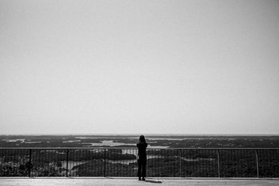 Man standing on field against clear sky