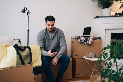 Young man looking away while sitting on chair