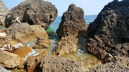 Panoramic view of rocks on beach against sky