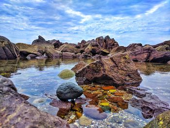 Rocks on beach against sky