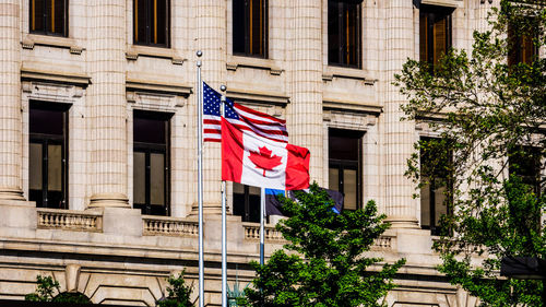 Low angle view of flag against buildings in city