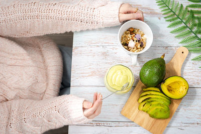 Healthy eating top view woman eat breakfast with avocado slice and smoothie on wooden board