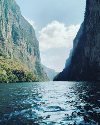 Scenic view of lake by mountains against sky