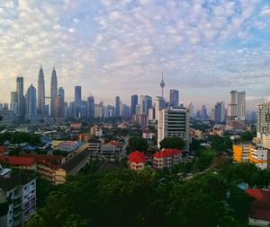 View of cityscape against cloudy sky