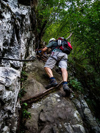 Full length of man climbing cliff