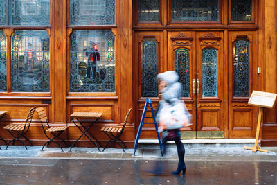 Full length of woman standing against wall
