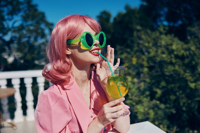 Young woman drinking juice outdoors