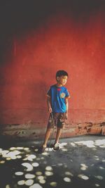 Full length of boy standing against wall