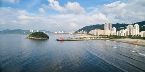 Panoramic shot of city by sea against sky