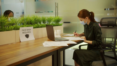 Woman working on table in office