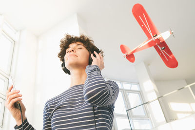 Low angle view of young man holding camera