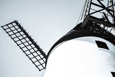 Low angle view of electricity pylon against clear sky