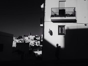 Silhouette man in city against sky