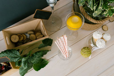 Waffle cone with white ice cream in a glass vase, paper tubes and a plant in a vase 