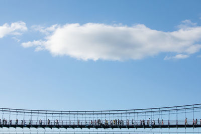 People on bridge against sky