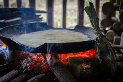 Close-up of cooking fire with iron pan onto cooking flat bread