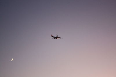 Low angle view of airplane flying against clear sky