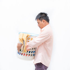 Side view of man standing against white background